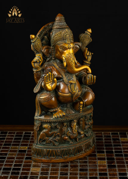 13" Lord Ganesh with Surya Halo seated on a pedestal with figurines of Ganesh and Lakshmi